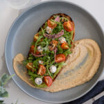 Avocado Smash Toast with Cherry Tomato, Arugula, Sherry Vinegar, Pickled Onion, Everything Bagel Spice, Hummus, Scallion Cashew Cream Cheeze